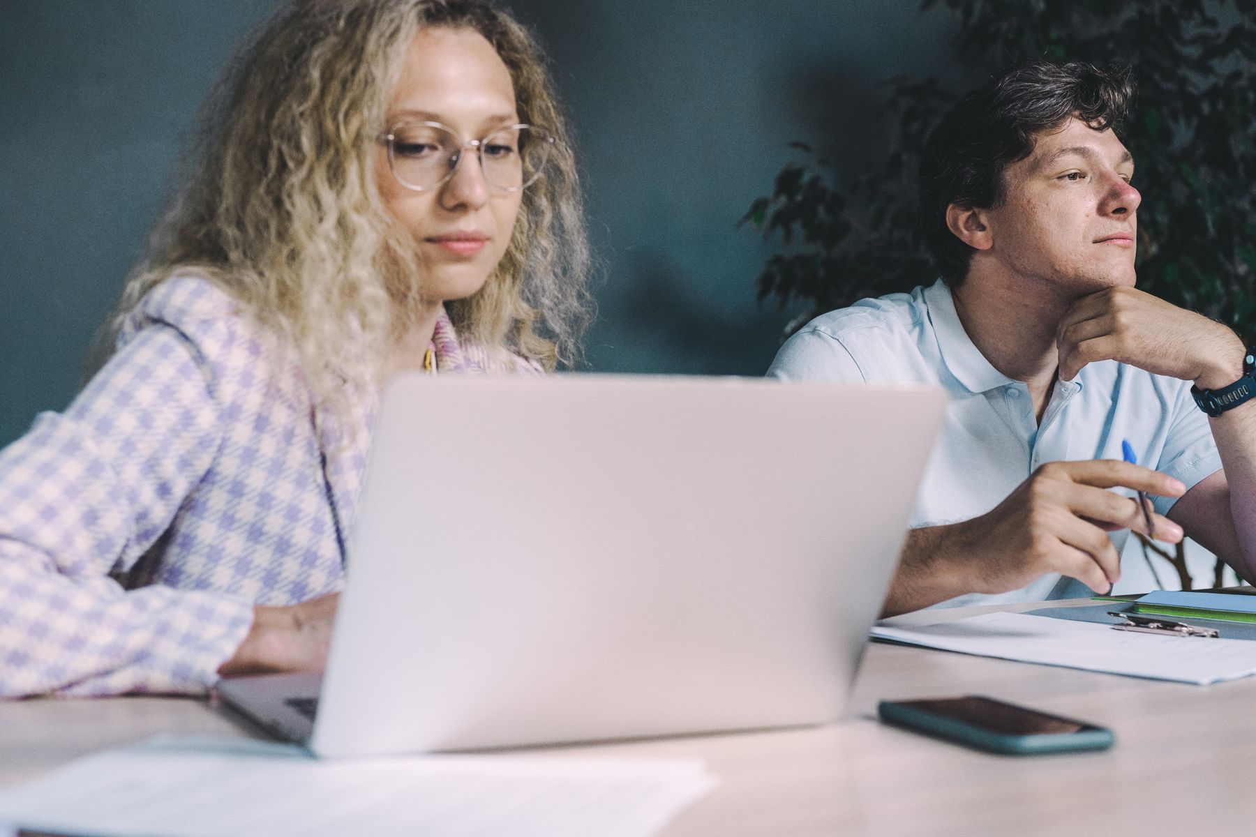 Twee collega’s kijken samen naar een laptop.